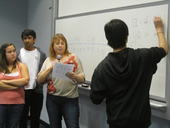 Diane from UC Davis explains her answer while her teammate Bob writes the calculation.